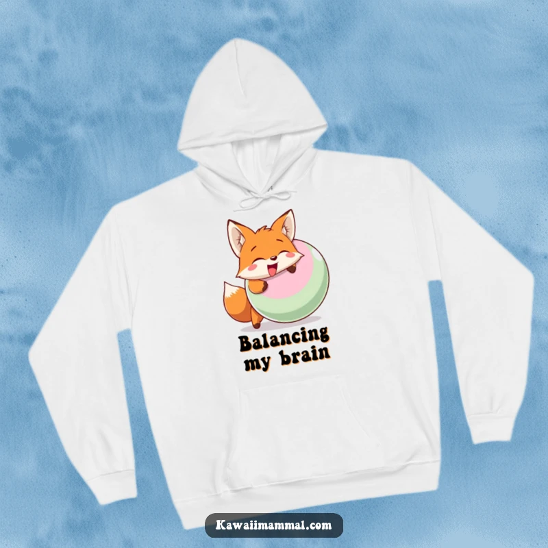 Funny hoodie with a smiling fox character enthusiastically head-butting a large inflatable ball, conveying playful energy.