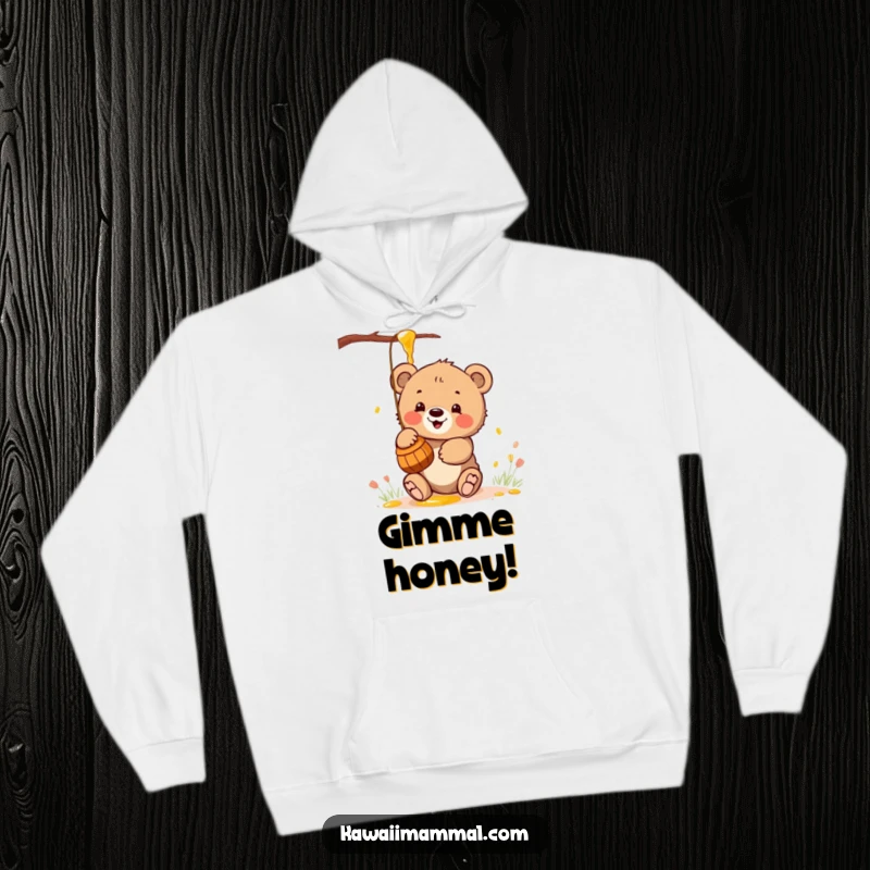 Funny hoodie with a kawaii bear cub enthusiastically reaching for a honey pot, offering warmth and adorable charm.
